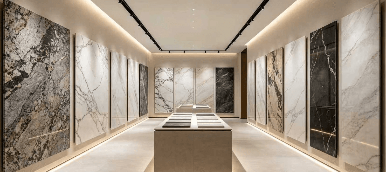 Stone showroom displaying full-height slabs and material sample tables